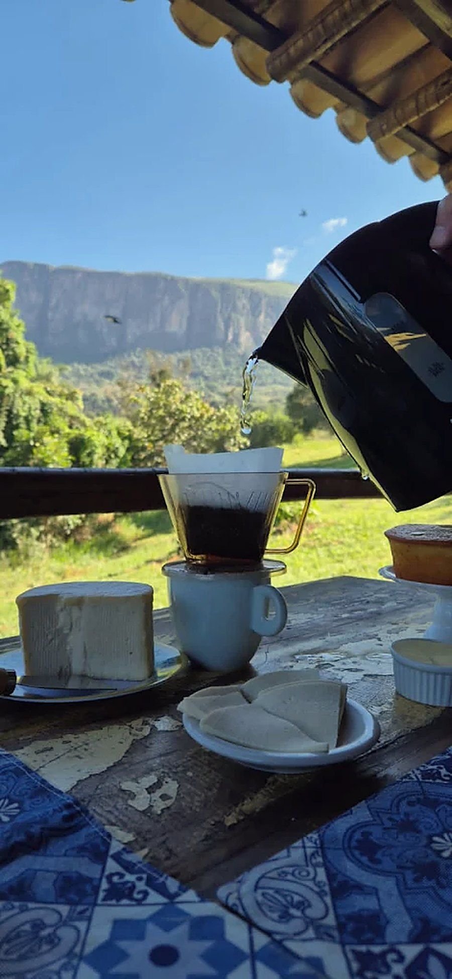 Café da manhã servido no deck com o paredão ao fundo